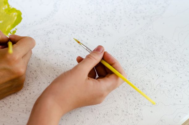 女人和孩子用画布上的颜料作画图片下载