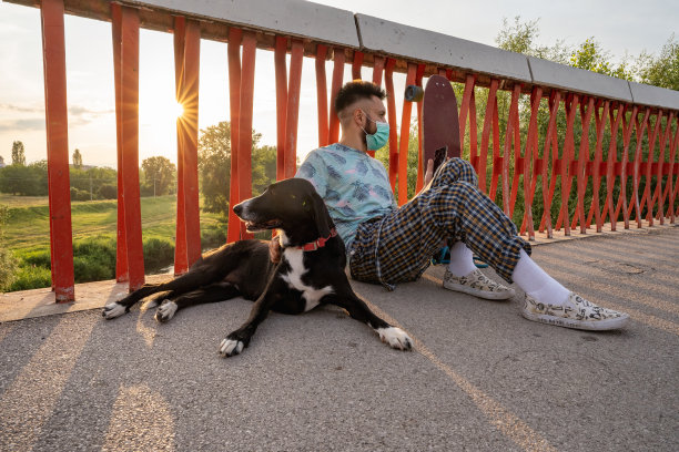 滑板手和他的狗在桥上玩图片下载