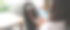 坐在客厅里的一个女人正拿着一部白屏幕的智能手机。图片下载