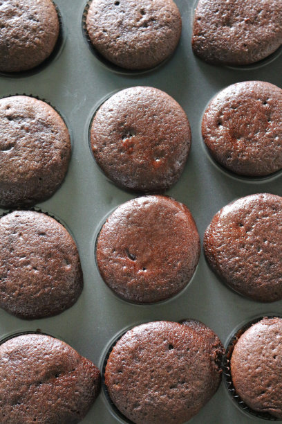 小松饼烤盘的形象，自制的巧克力纸杯蛋糕在棕色的纸蛋糕盒，家庭烘焙，俯瞰图片下载