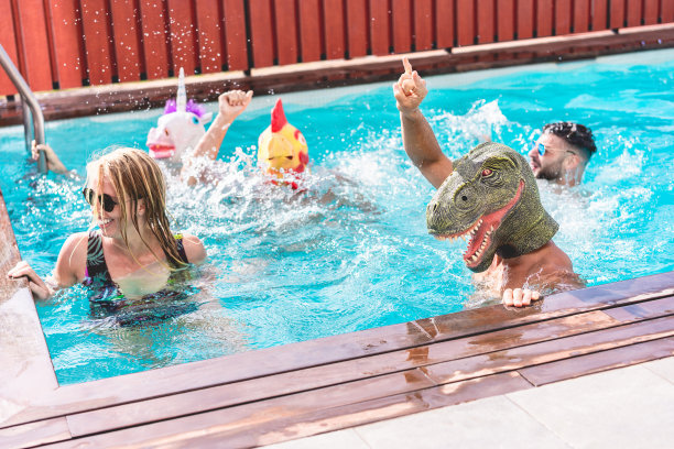快乐的人们做游泳池私人派对，而戴着有趣的动物面具-年轻的朋友在夏天开心-在冠状病毒爆发期间的另类fest -专注于恐龙脸图片下载