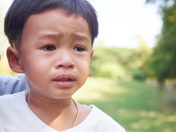 那个亚洲小男孩在哭。他的脸上带着泪水。图片下载