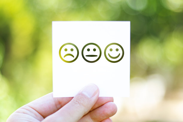 在美丽模糊的自然背景前拿着写有表情符号的纸图片下载