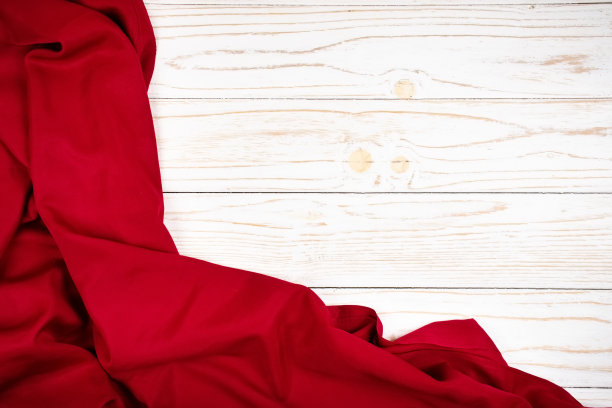 白色木板上的红色或红宝石色纺织品或织物的褶皱图片下载