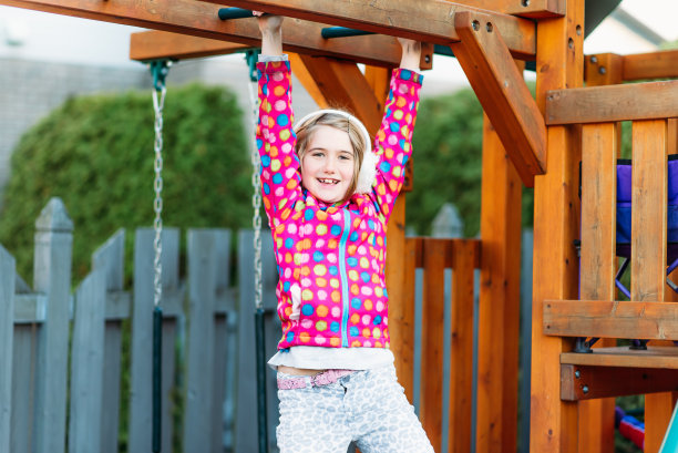 一个快乐的7岁小女孩缺了一颗牙，她在玩游戏的时候看着摄像机。图片下载