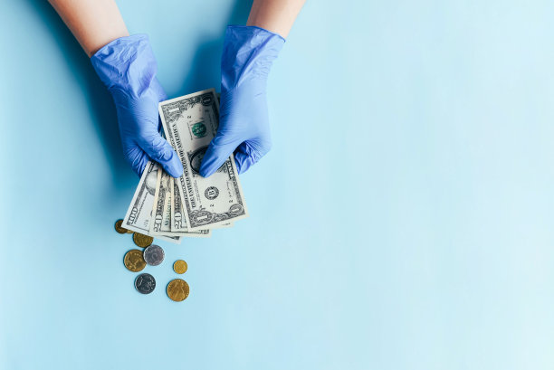双手戴着手套数美元货币。图片下载