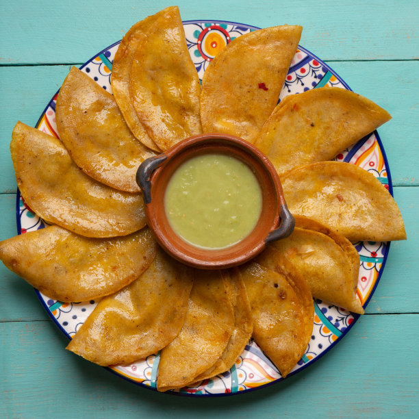 墨西哥篮子玉米饼也称为canasta与绿色酱在绿松石背景图片下载