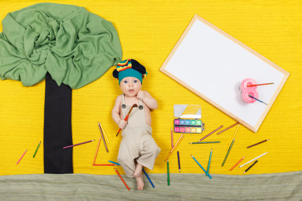 小男孩画艺术作品。英俊的孩子躺在黄色的背景上图片下载