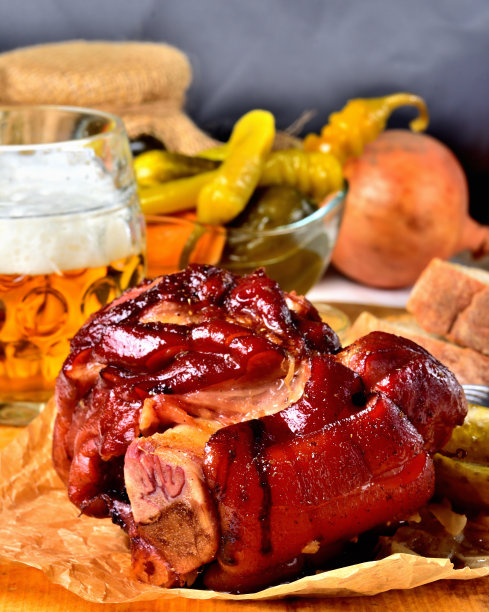 特写烤烟熏猪肉与啤酒，芥末，泡菜和山羊角胡椒蔬菜。垂直的照片。仍然生活。传统的德国菜。图片下载
