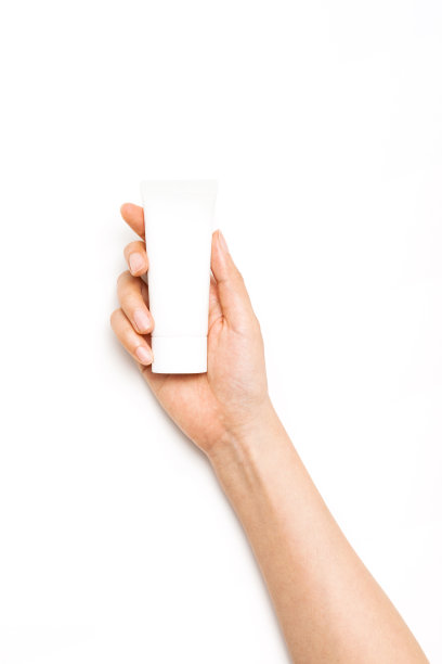 女人手拿化妆品容器上的防晒霜在白色的背景。图片下载