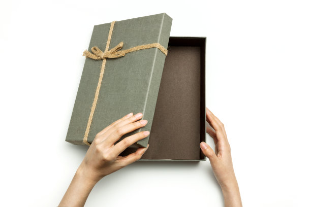 在白色的背景下，一个女人手拿着一个灰色的盒子。图片下载