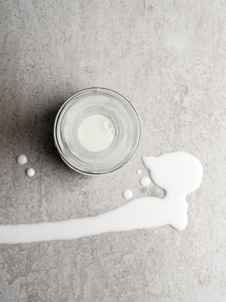 溢出的牛奶，从瓶子溢出的牛奶，牛奶溅在背景上的俯视图，图片下载