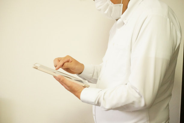 戴着口罩操作平板电脑的商人图片下载