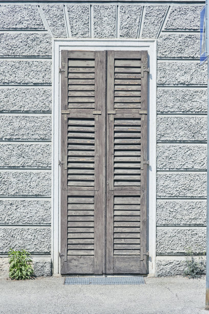 灰色砖瓦外墙上的意大利窗与封闭的棕色片状经典百叶窗图片下载