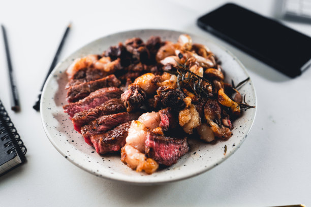 牛排片放在家里桌子上的盘子里。图片下载