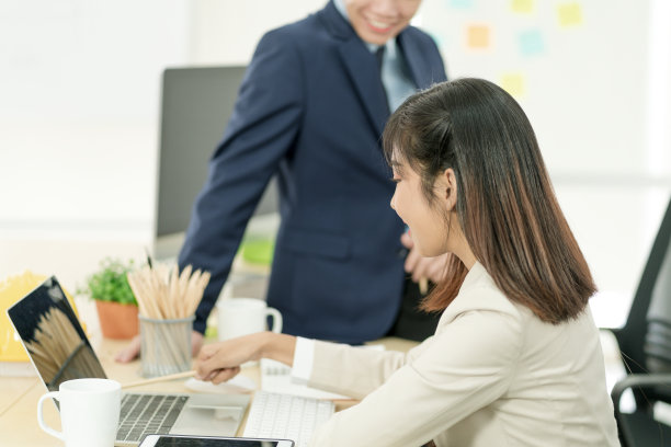 亚洲商务女性在用笔记本电脑聊天。员工在办公室讨论工作。图片下载