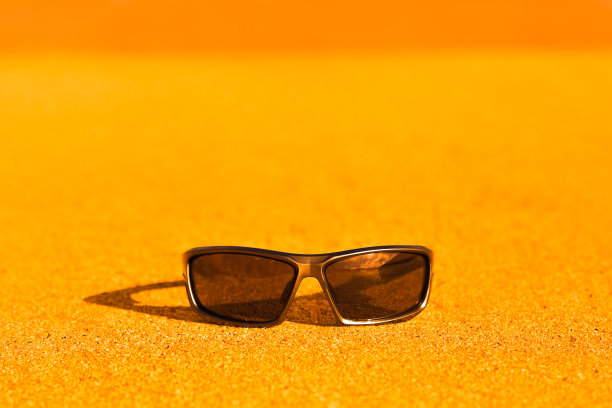 炎热夏日沙滩上的运动太阳镜图片下载