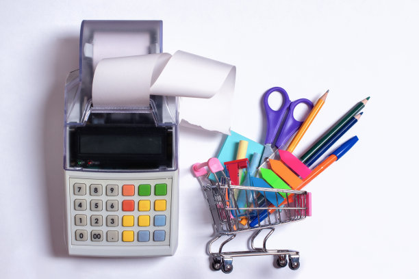 顶视图照片的购物手推车与彩色文具和收银机与收据胶带图片下载