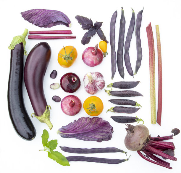 白色盘子上放紫色蔬菜和黄色番茄。时尚的概念。广告、横幅、海报。图片下载