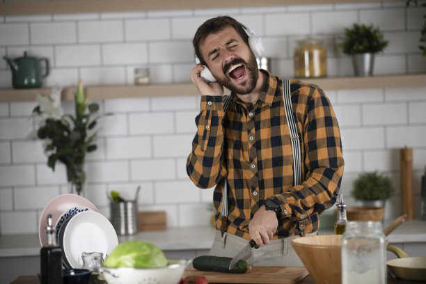 年轻有魅力的男人在厨房唱歌图片下载