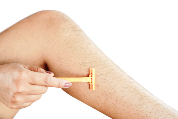 特写女人的手刮毛腿被刀片孤立在白色的背景图片下载