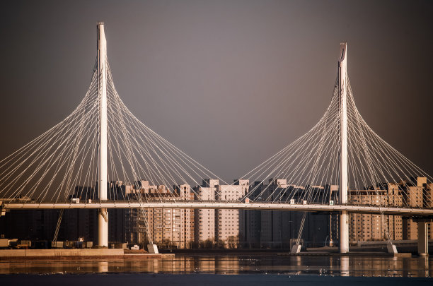 现代大桥横跨在海上的圣彼得堡芬兰湾与天空的云彩和现代建筑和海浪。图片下载