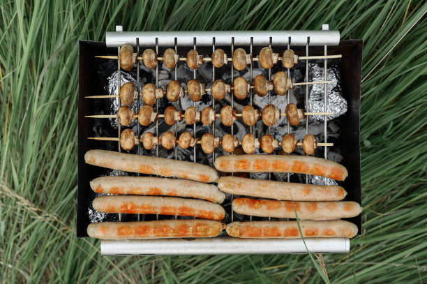 烤架上的香肠和蘑菇俯视图。图片下载