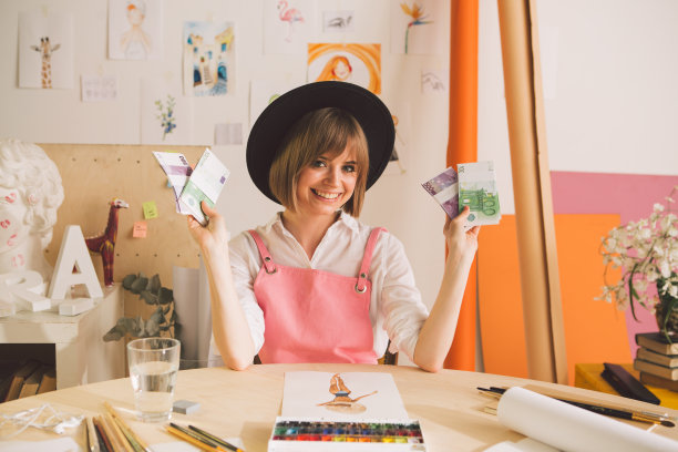 创意快乐的女孩在帽子艺术家或插画家坐在现金在她的工作室关于艺术和自由职业者的概念照片图片下载