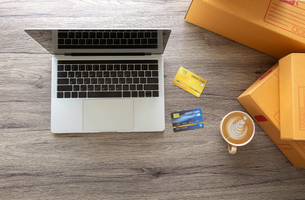自顶向下的照片与复制空间的笔记本电脑放置在木桌与智能手机，装满盒子和信用卡，用于网上商店购物和电子商务的数字生活方式。图片下载