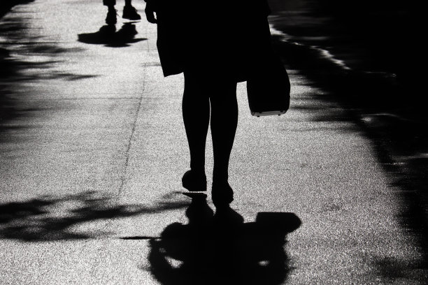 一个女人走在街上的剪影和影子图片下载