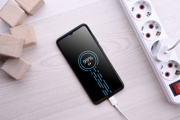 在木桌上用延长线给手机充电。近距离图片下载