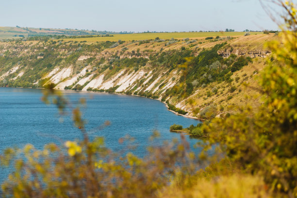 照片美丽的风景与湖泊和白色的石头田野在一个阳光明媚的日子图片下载