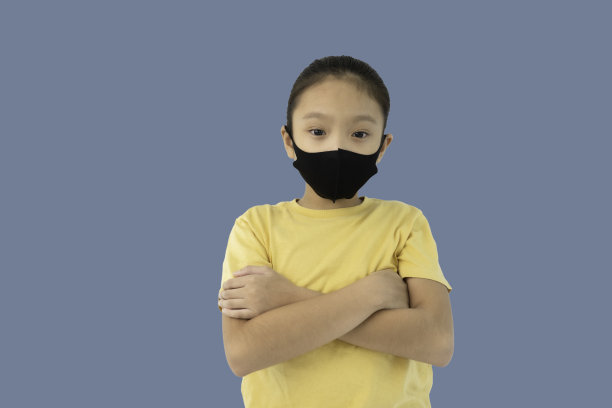 肖像小亚洲女孩戴着医用口罩，孤立图片下载