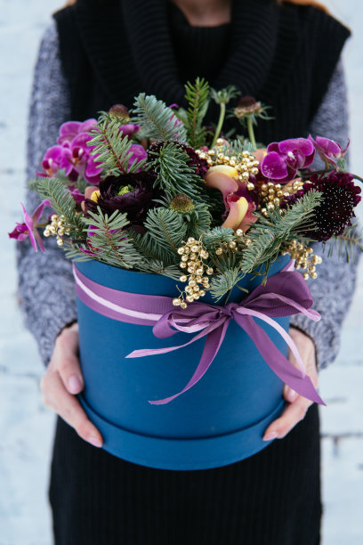 一束花和冷杉枝放在蓝帽盒里图片下载