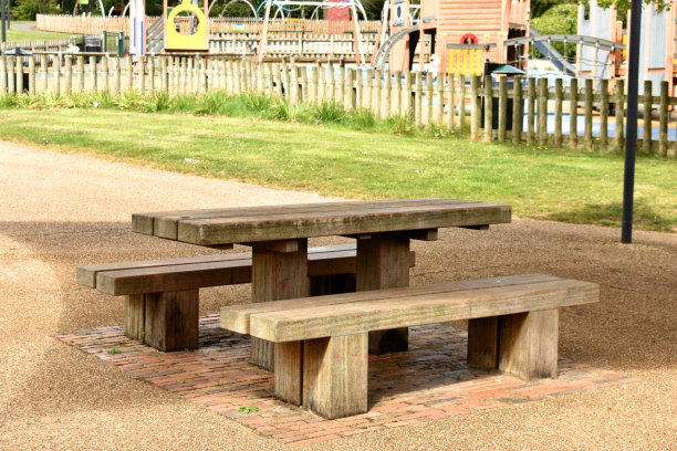 空的公园长椅和桌子，在封闭期间在无人的公共游乐场野餐图片下载