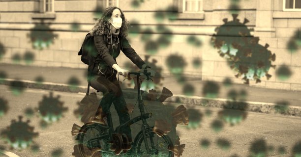 Covid-19细胞针对在道路上骑自行车戴口罩的妇女图片下载