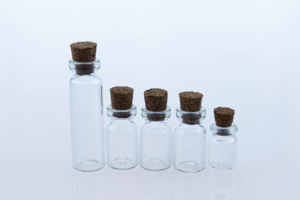 清空用木塞密封的透明小玻璃瓶。物体反射在表面上就像在镜子里一样。宏图片下载