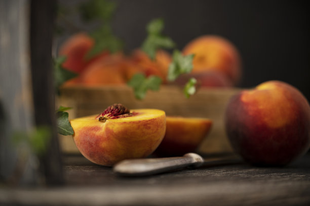 鲜玫瑰配黄桃，其中一个在木椅上用刀切成片。中间有块骨头图片下载