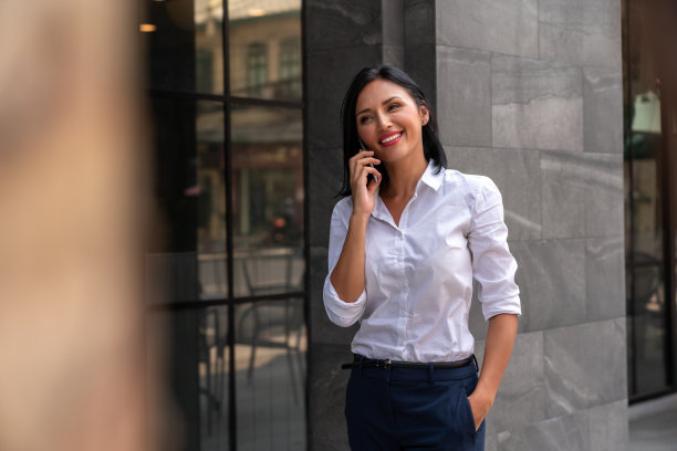 快乐的女商人在人行道上使用手机图片下载