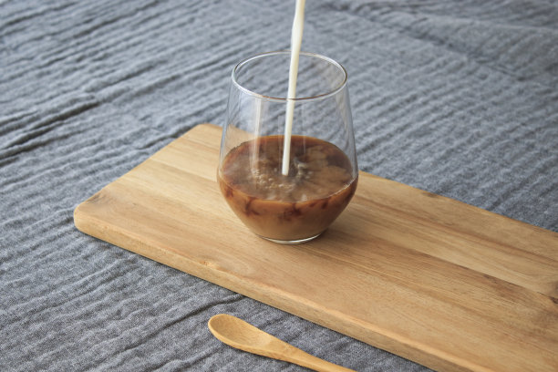 拿铁咖啡和木勺站在木头上，灰盖上，孤立背景图片下载