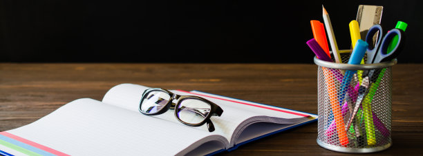 回到学校。打开空白的笔记本与眼镜和学校文具的黑板背景。教育的概念。图片下载