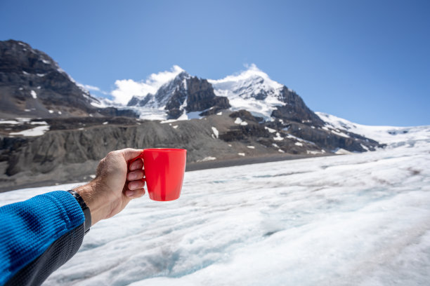 加拿大贾斯珀国家公园哥伦比亚冰原上的一只手正在展示一个咖啡杯图片下载