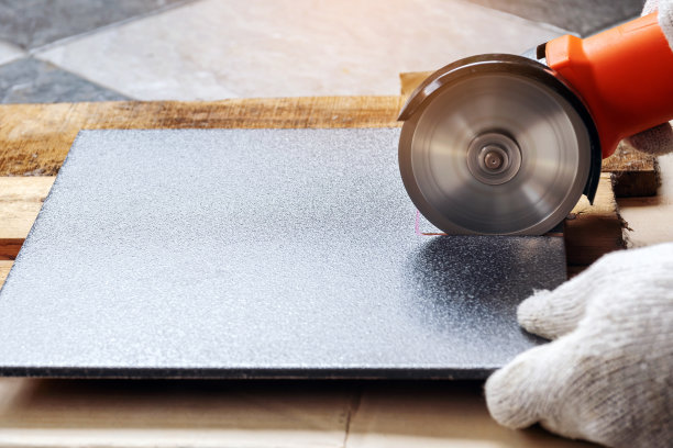 用电动研磨机切割瓷砖。图片下载