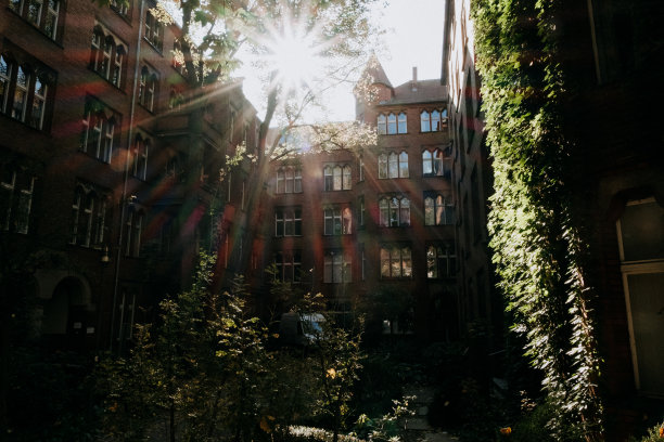 有一个大太阳耀斑的旧红色建筑图片下载
