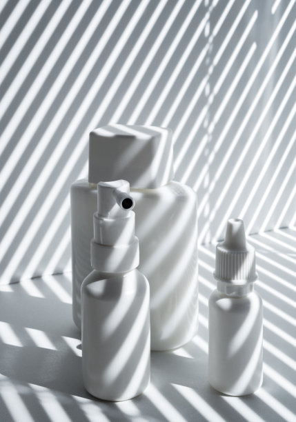 阳光下的三个白色塑料和玻璃小瓶图片下载