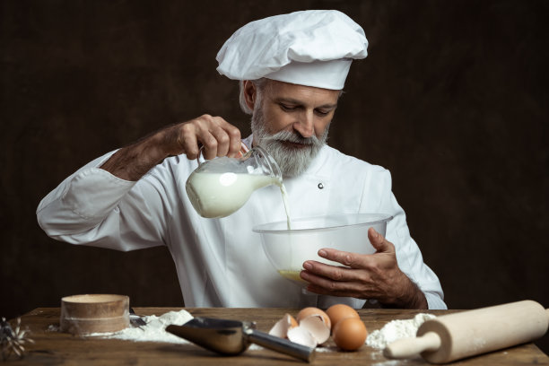 面包师在黑色背景上烤面包图片下载