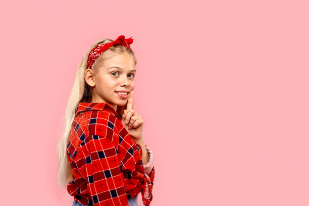 十几岁的女孩看着相机，把手指放在嘴唇附近图片下载