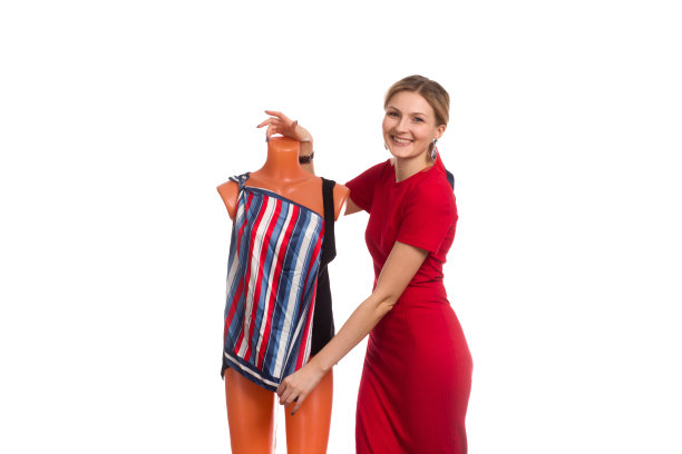 一个身穿红色连衣裙的年轻女子给模特穿上条纹连衣裙图片下载