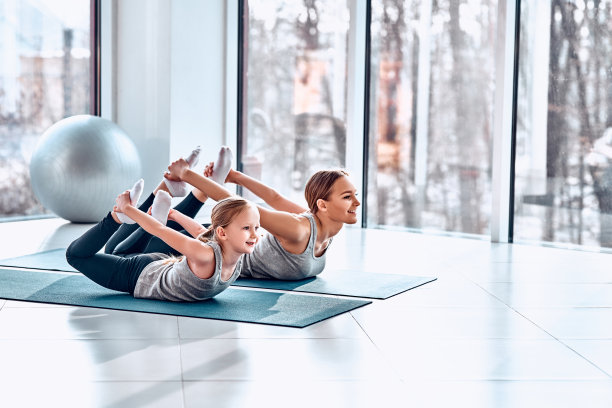 母亲和女儿在家里的地毯上做瑜伽练习。图片下载