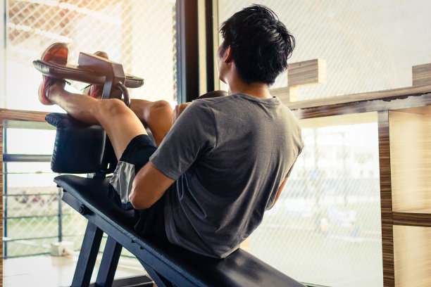 特写的年轻亚洲夫妇做仰卧起坐在健身房。锻炼的概念。健康的概念。健身肌肉发达的身体。图片下载